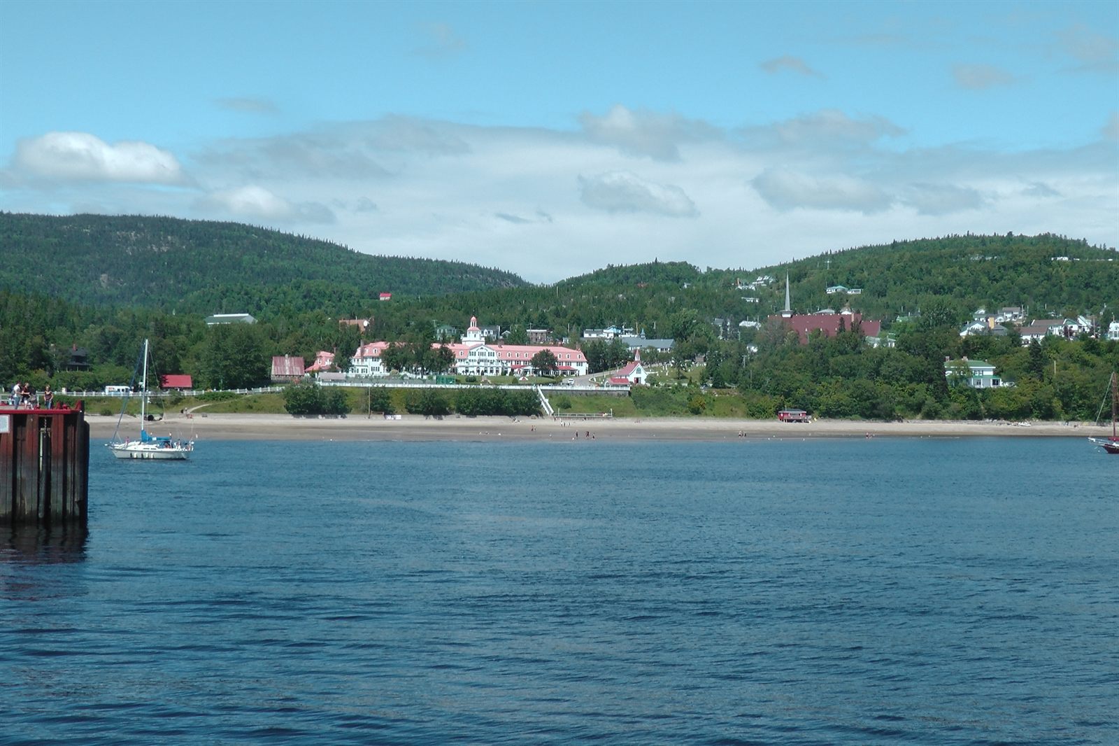 Green hills and a riverside village in Charlevoix seen from the St. Lawrence River