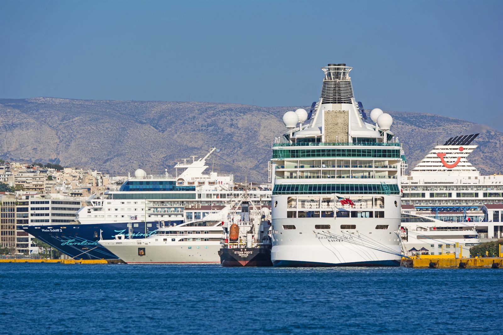 Several cruise ships docked side by side in a busy Mediterranean port